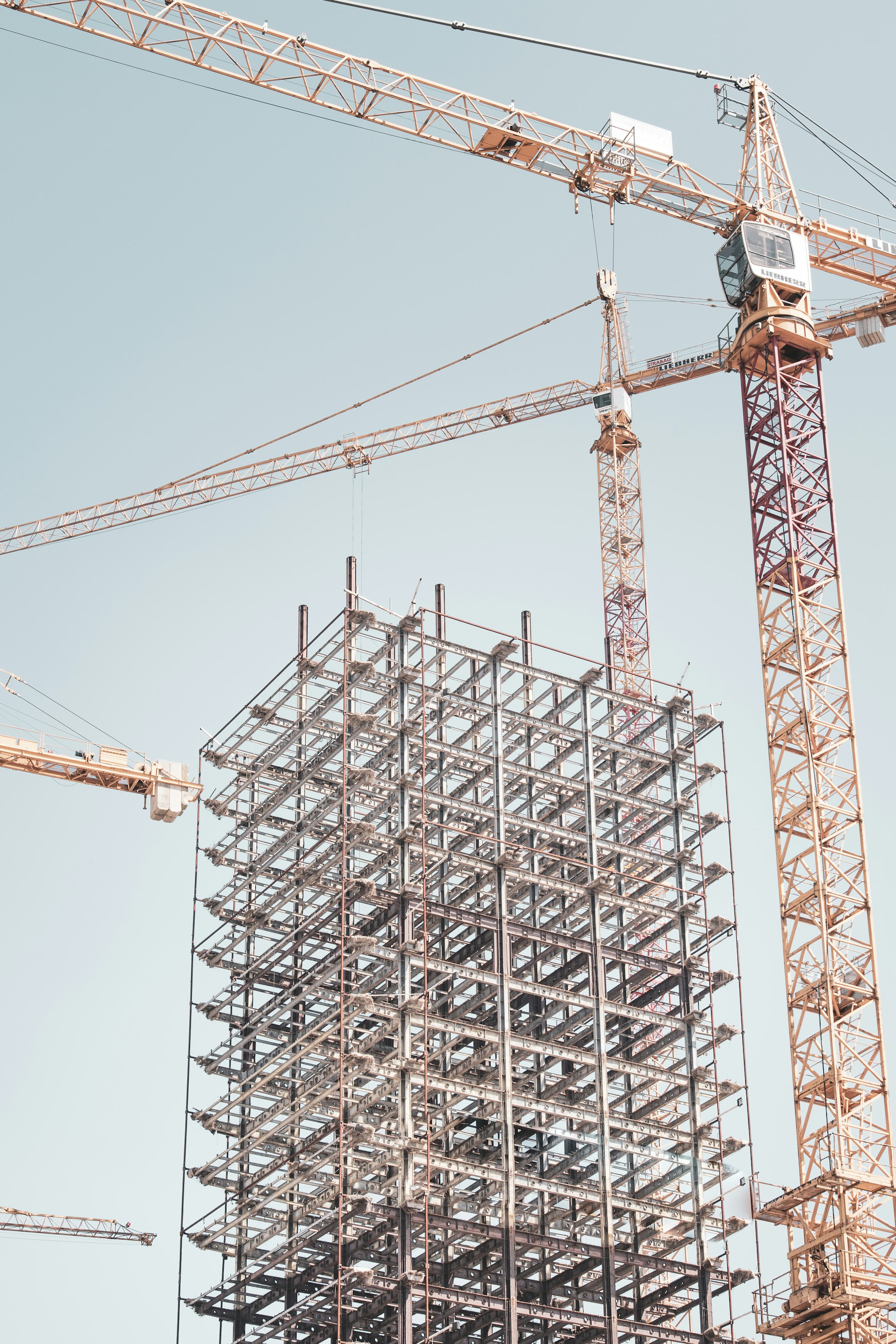 Building frame and cranes — illustrative photography, not an OSFI project or South Sudan location.